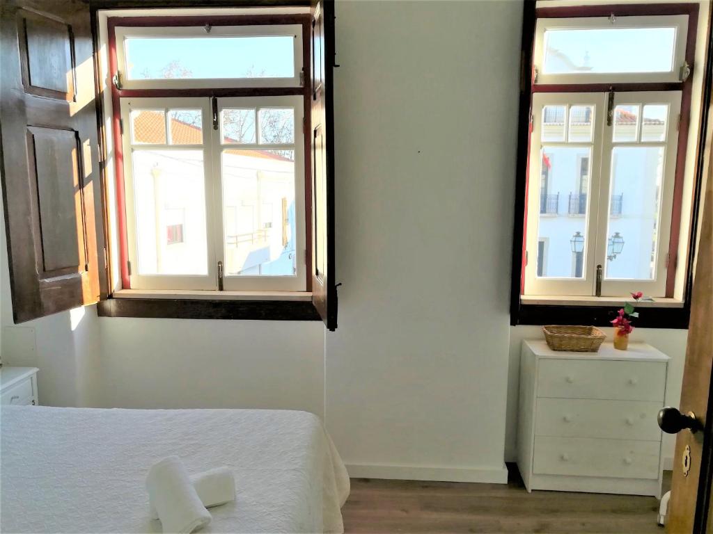1 dormitorio con 2 ventanas y 1 cama blanca en Casa da Vila en Vila Nova da Barquinha