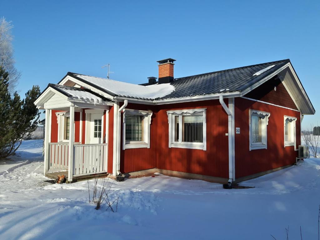 una casa roja con nieve en el suelo en Simon tupa Kauhajoki, en Kauhajoki