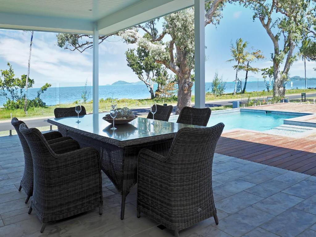 a dining room with a table and chairs and a pool at Solace in South Mission Beach