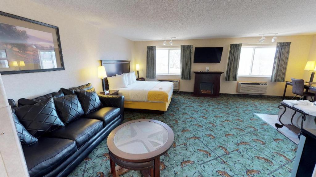 Habitación de hotel con cama y sofá en Stay Wise Inns of Montrose, en Montrose