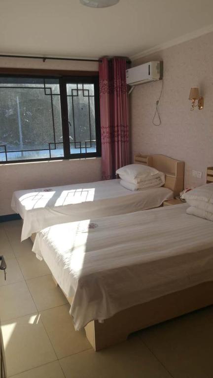 Postel nebo postele na pokoji v ubytování Jumanyuan House