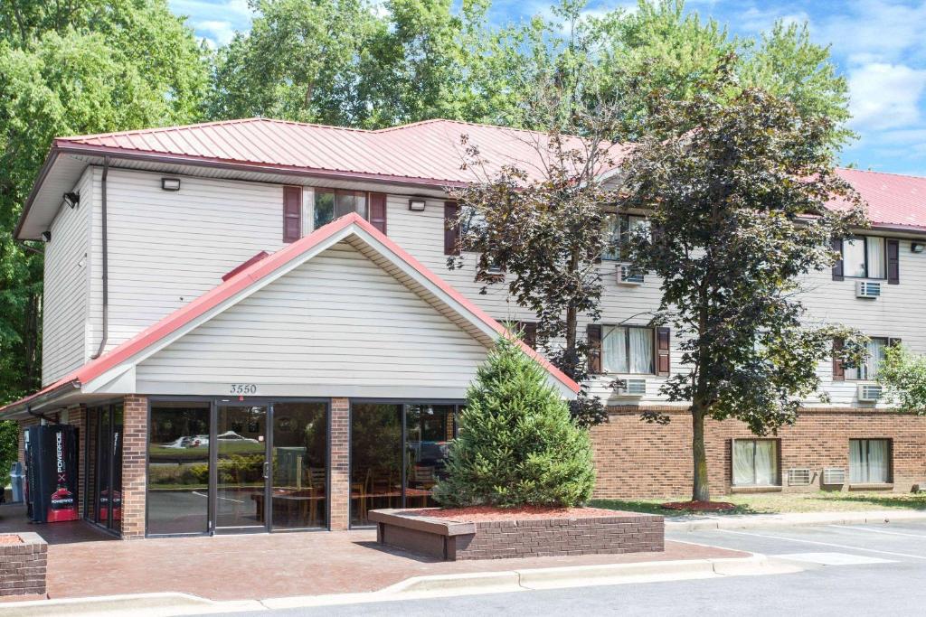 a building with a tree in front of it at Super 8 by Wyndham Waldorf in Waldorf