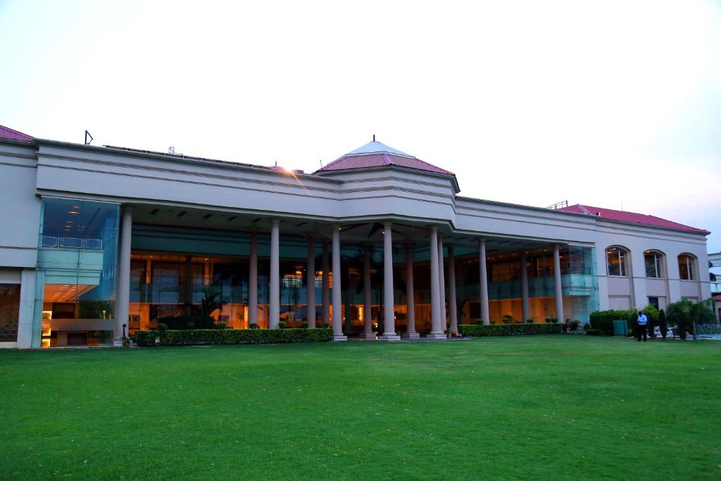 a large building with a lawn in front of it at The Cabbana Resort & Spa in Phagwāra
