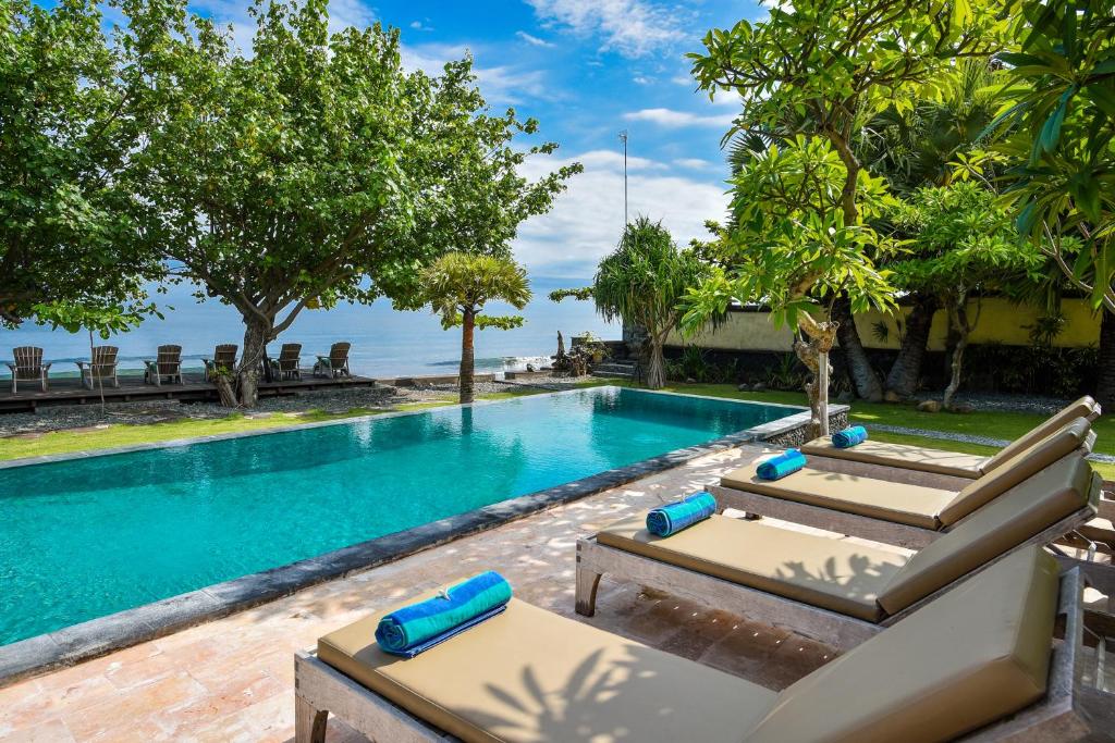 una piscina con due lettini accanto a un resort di Villa Semadhi a Pemuteran