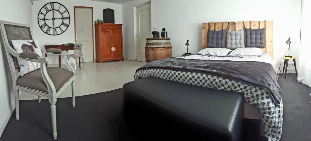 a bedroom with a large bed and a chair at Chambre au tonneau in Fleurie