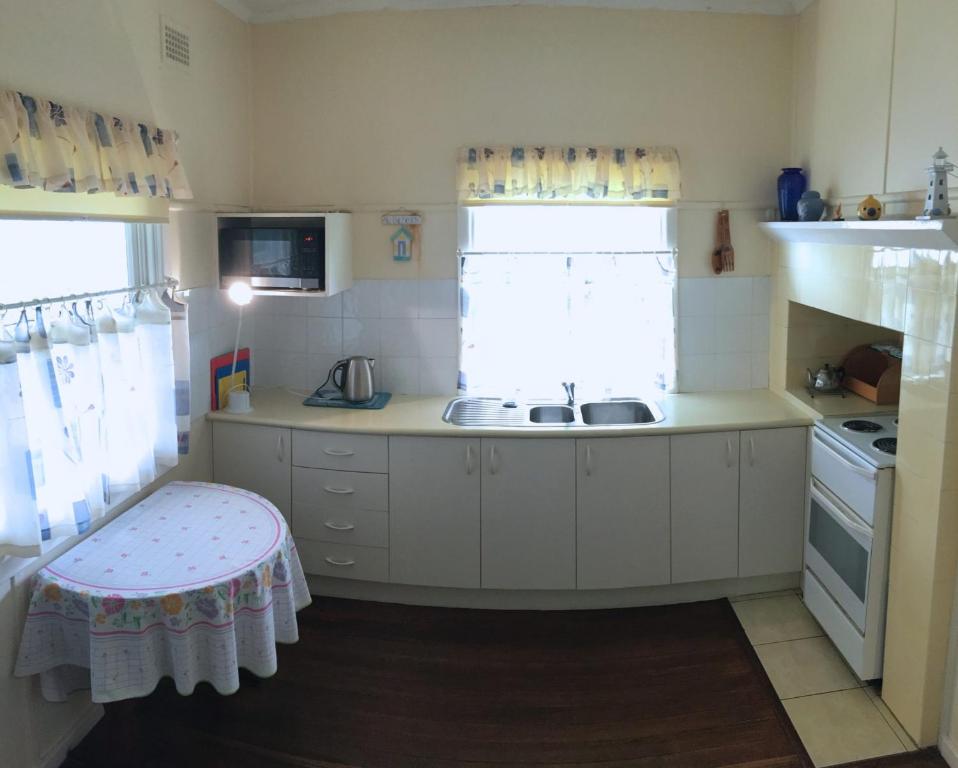 a small kitchen with a sink and a stove at Lorikeet Retreat, 11 Hodgson Street in Crescent Head