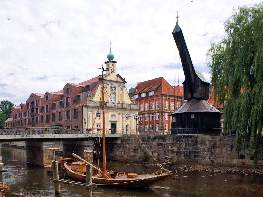 ein Boot im Wasser neben einer Brücke in der Unterkunft DORMERO Hotel Altes Kaufhaus in Lüneburg