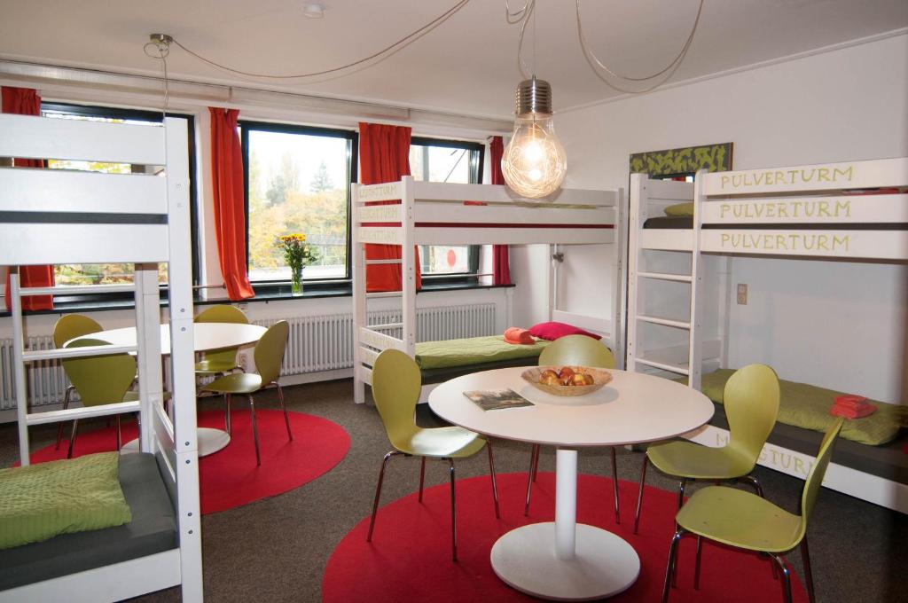 a room with bunk beds and a table and chairs at Inselhostel in Lindau