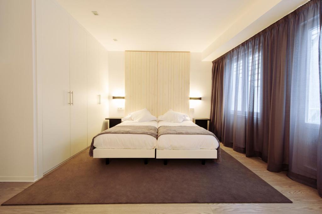a bedroom with a white bed and a large window at Hotel Lois in A Coruña