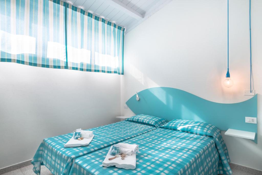 a bedroom with a bed with two towels on it at Villaggio San Francesco in Duna Verde