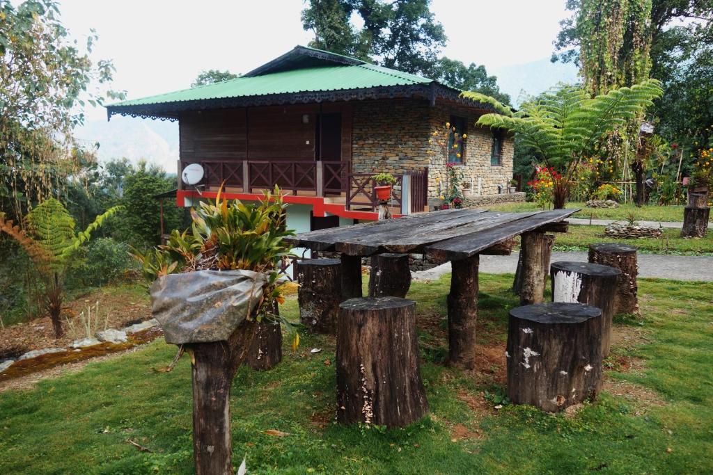 una mesa de picnic de madera frente a un edificio en The Barfung Retreat en Gangtok