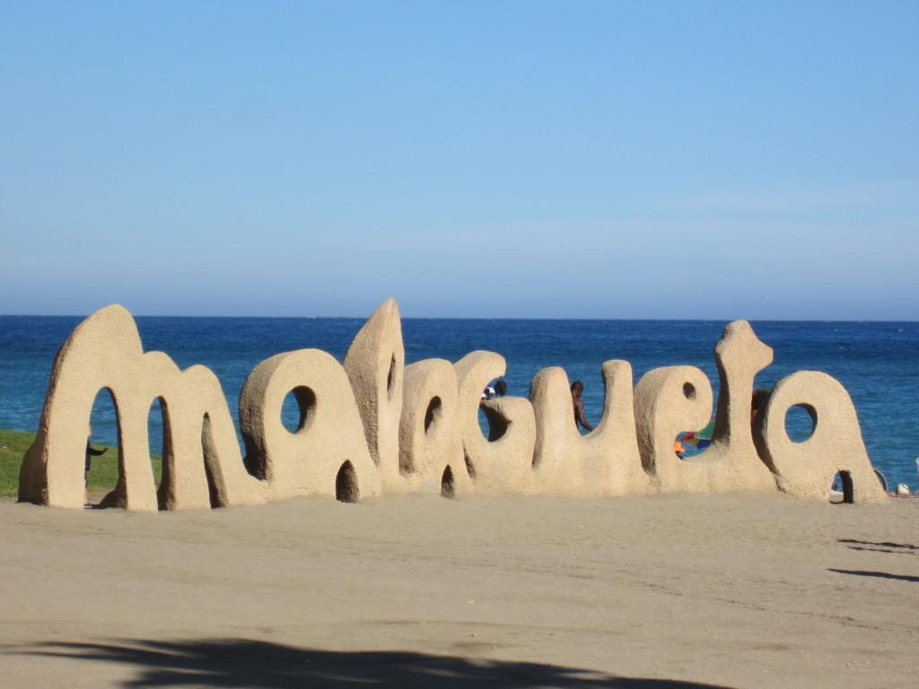 una escultura de arena de la wordambulation en la playa en Living4Malaga Centro Histórico y Playa, en Málaga