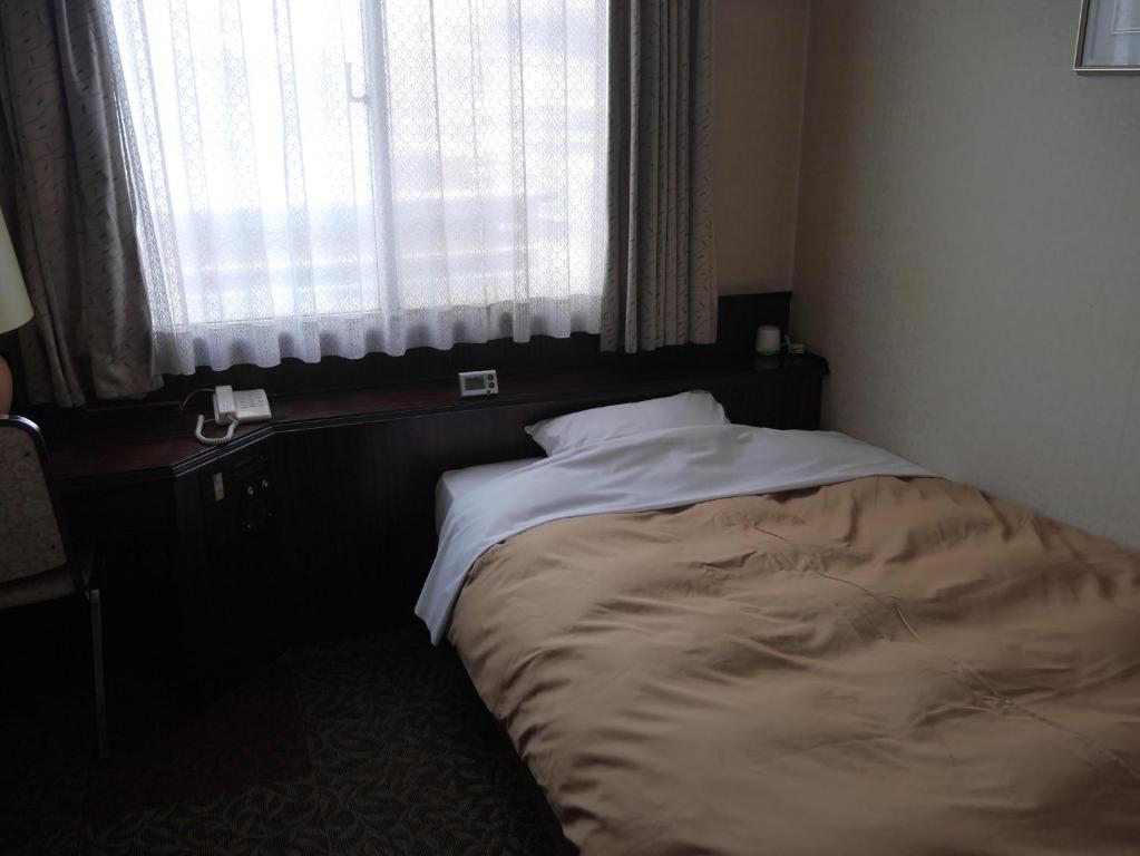 Postel nebo postele na pokoji v ubytování Hotel CROWN HILLS MIYOSHI