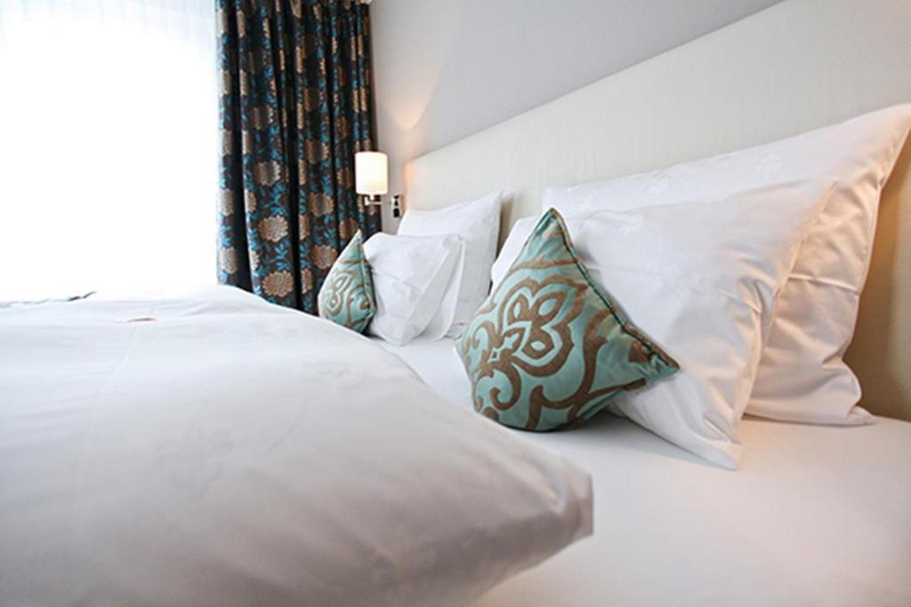 ノイシュタット・アン・デア・ヴァインシュトラーセにあるHotel Palatina "Hotel-Restaurant"の白い枕と窓が備わる白いベッド