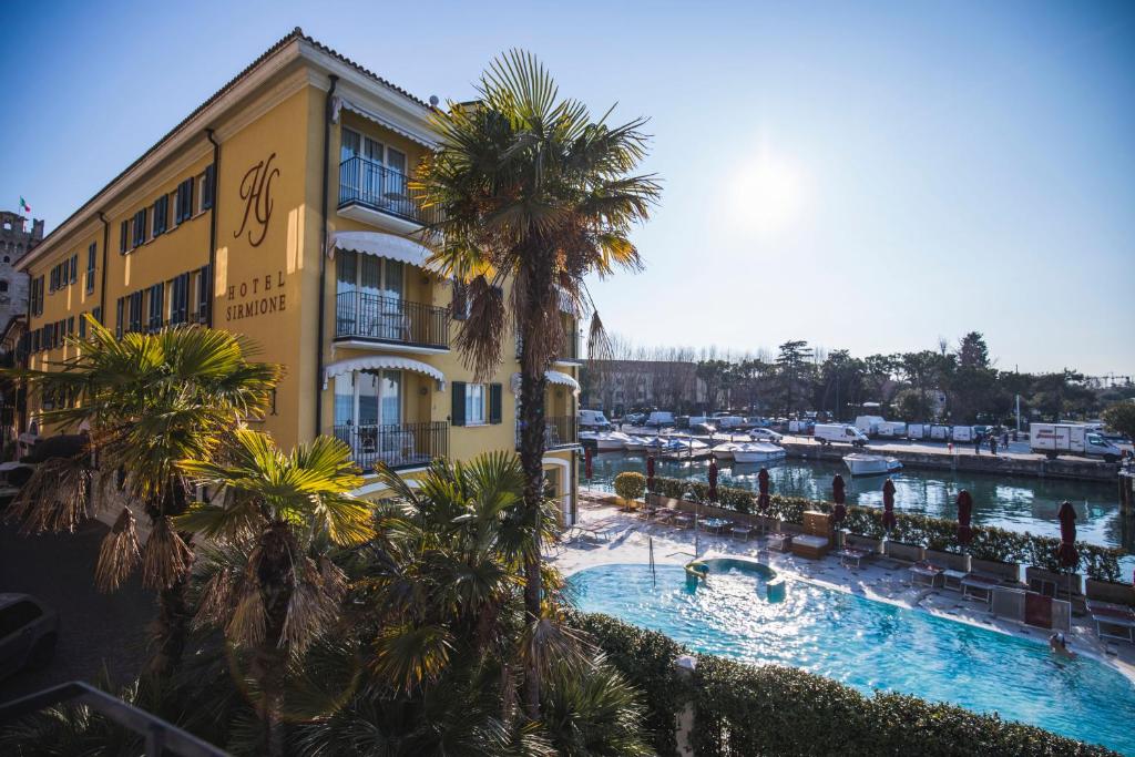 een hotel met een zwembad naast een jachthaven bij Hotel Sirmione in Sirmione