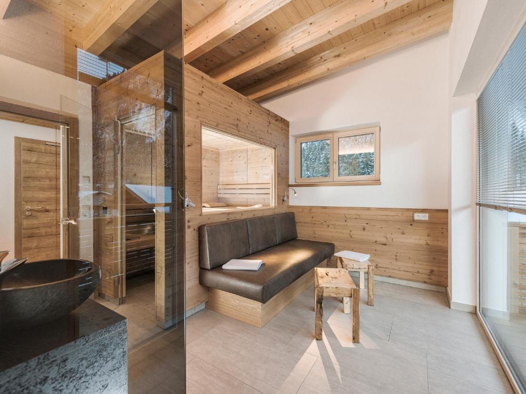 two pictures of a bathroom with a bench and a tub at SonnenNEST mit SAUNA in Mayrhofen