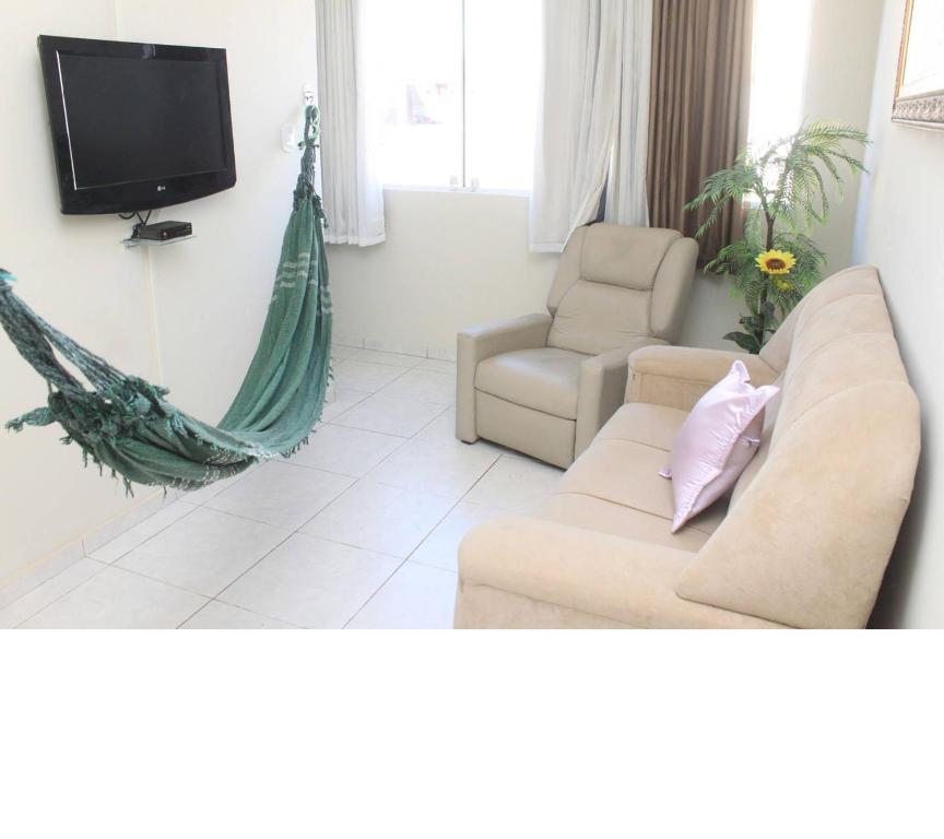 a living room with a couch and a tv and a hammock at Excelente apartamento centro Paulo Afonso in Paulo Afonso