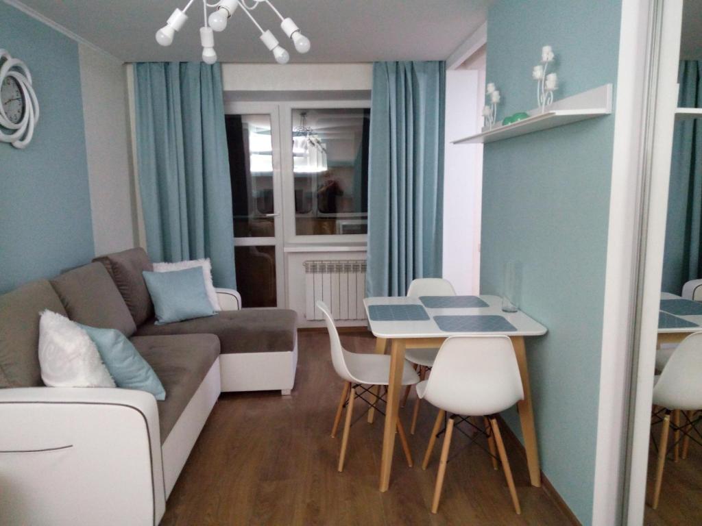 ein Wohnzimmer mit einem Sofa und einem Tisch in der Unterkunft Two-bedroom apartment in the center in Chmelnyzkyj