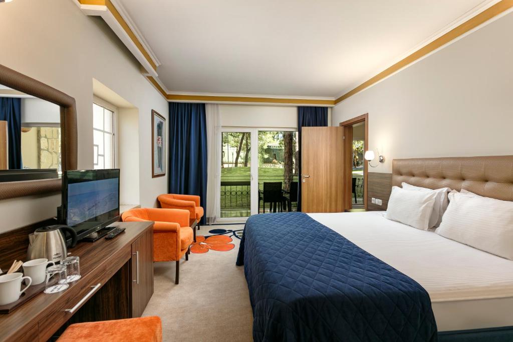 a hotel room with a bed and a television at Pine Beach Belek in Belek