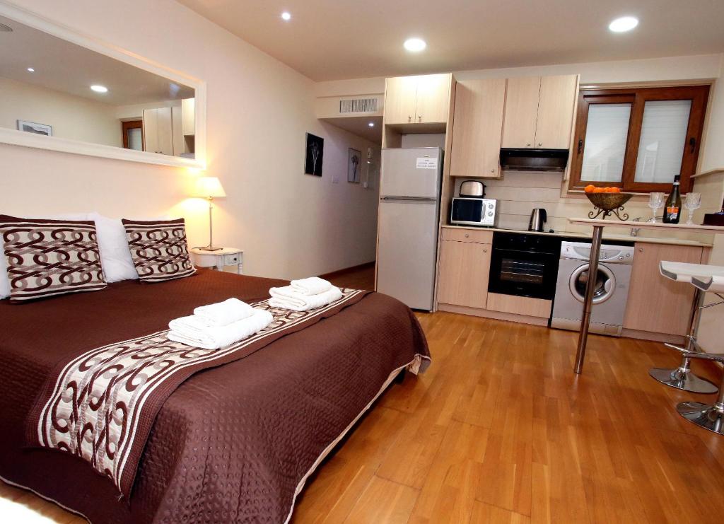 1 Schlafzimmer mit einem großen Bett und einer Küche in der Unterkunft Ithaki Phinikoudes Apartment 307 in Larnaka