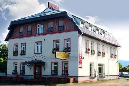 a large white building with a sign on it at Pensiunea Byblos in Piatra Neamţ