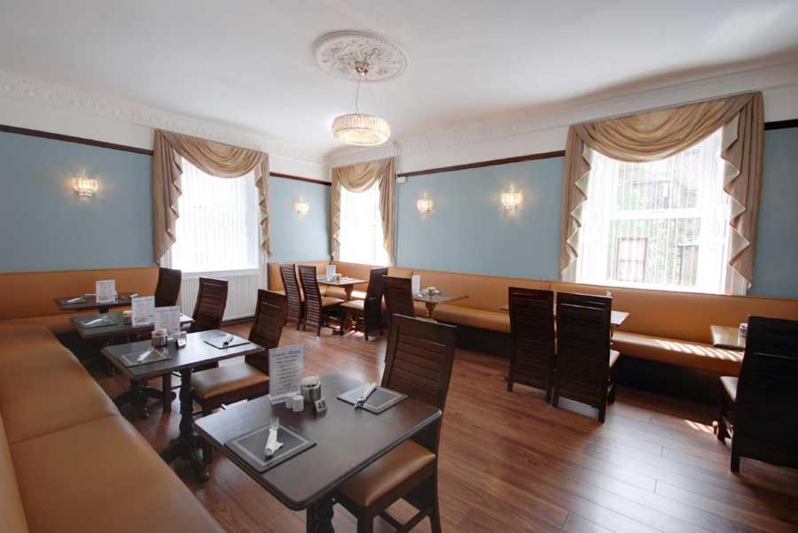 a restaurant with tables and chairs and a couch at Waverley Hotel in Peterhead