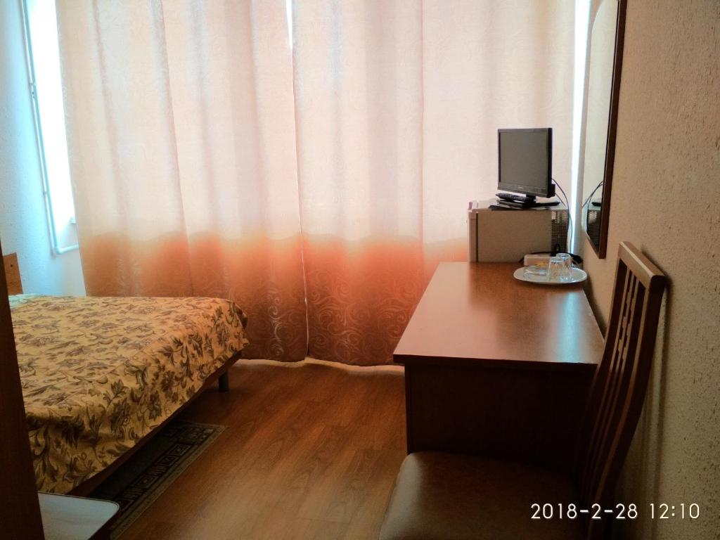 a bedroom with a desk and a bed with a television at Hotel Zvenigorod in Zvenigorod