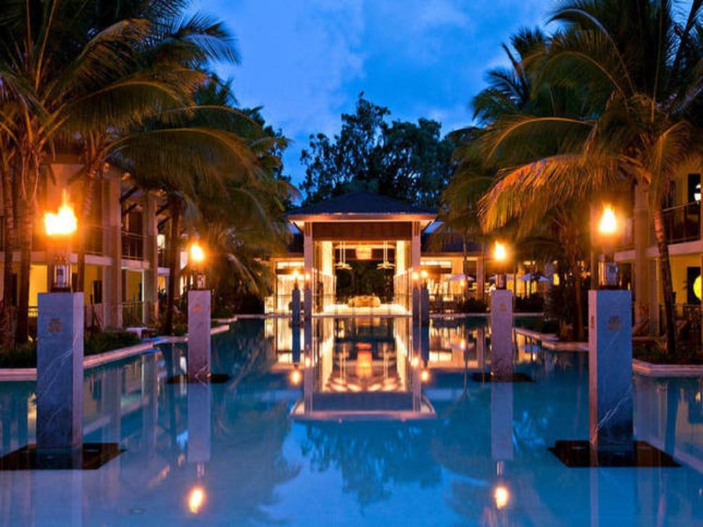 a resort with a swimming pool at night at Luxury Apartments at Temple Resort and Spa Port Douglas in Port Douglas