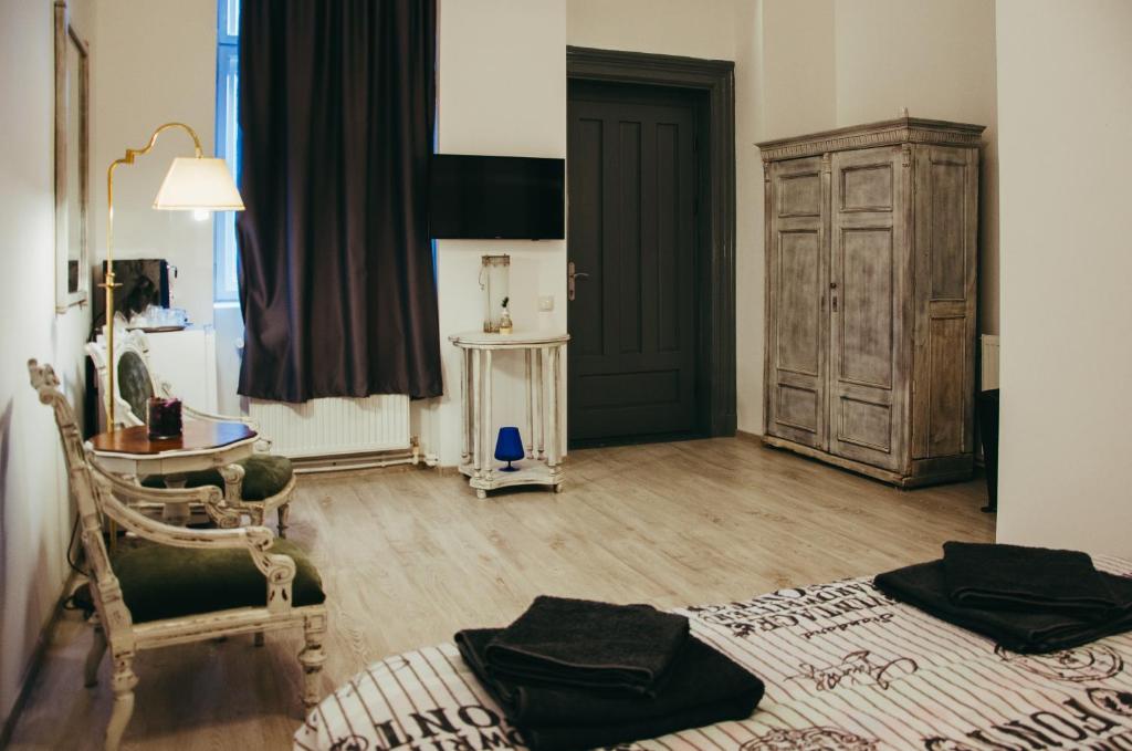 um quarto com uma cama, uma mesa e uma porta em Mansion Josephina em Cluj-Napoca