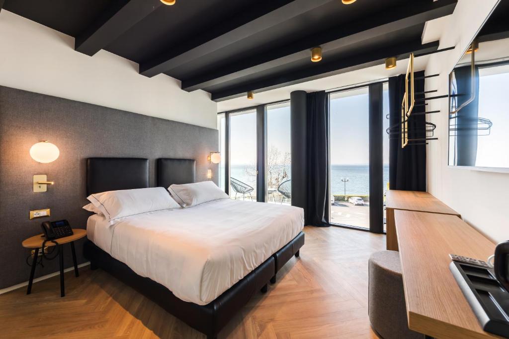 a bedroom with a large bed with a view of the ocean at MaisonMe Boutique Hotel in Bardolino