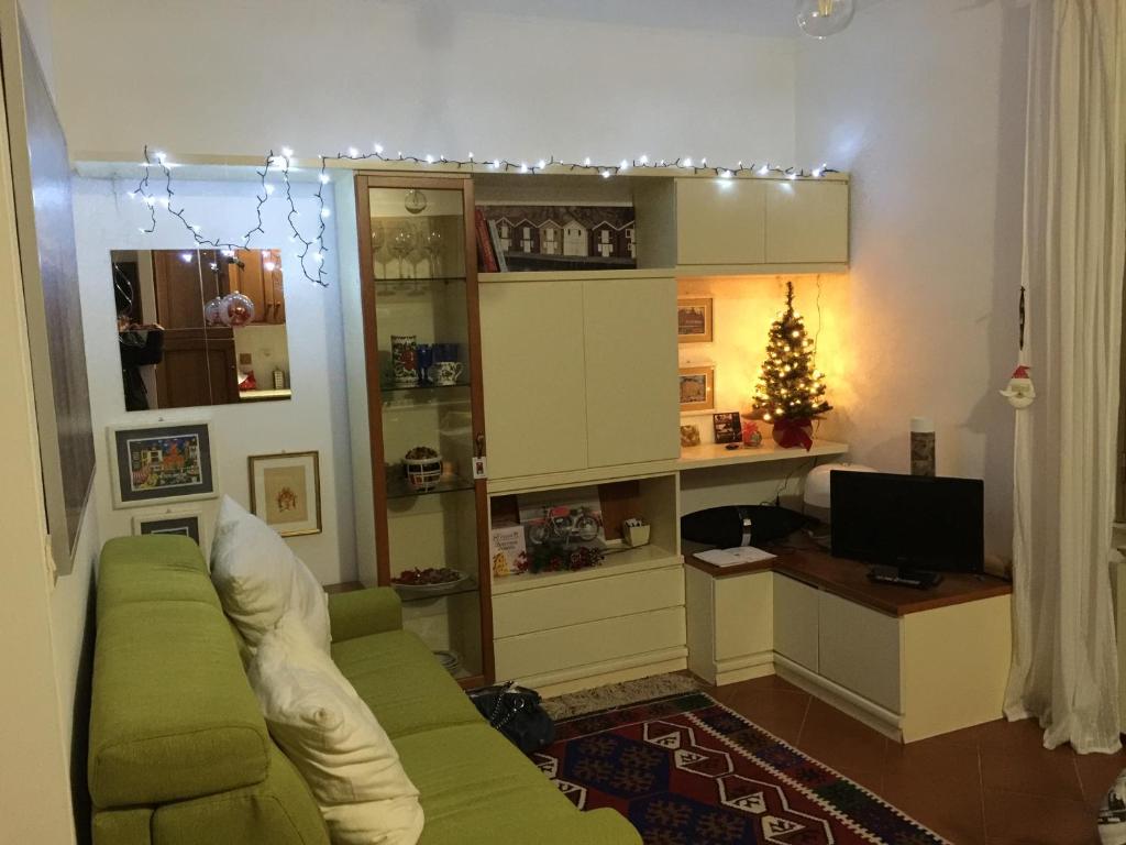 a living room with a green couch and a christmas tree at Lovely Irnerio ❤ flat near S. Pietro ★ in Rome