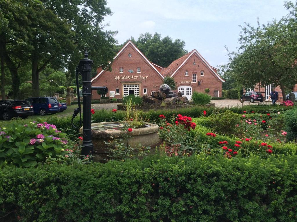 einen Garten mit Blumen vor einem Gebäude in der Unterkunft Landhotel Waldseiter Hof in Bad Bentheim