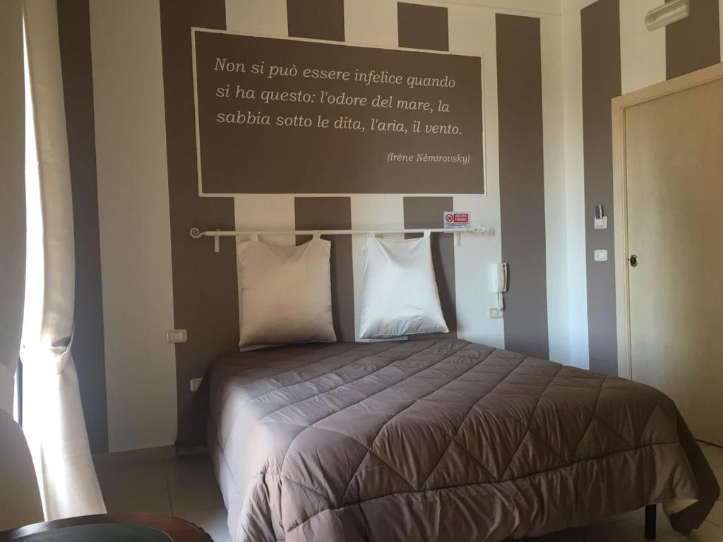 - une chambre avec un lit et un panneau mural dans l'établissement La Perla delle Saline, à Margherita di Savoia