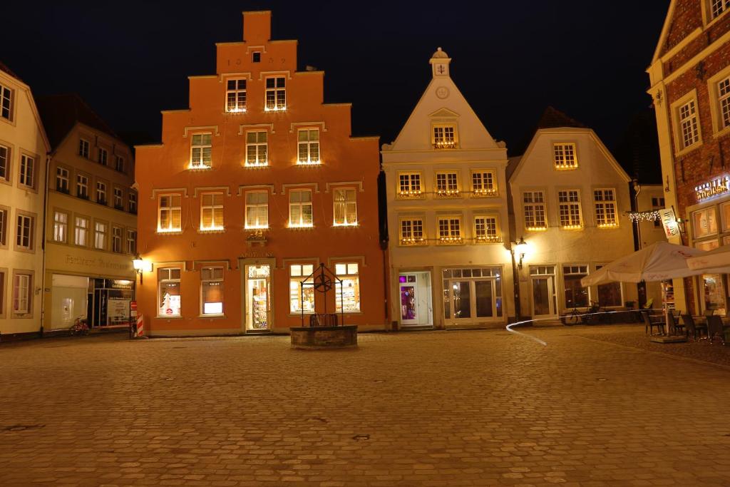 a city street at night with buildings and lights at Markthotel Warendorf in Warendorf