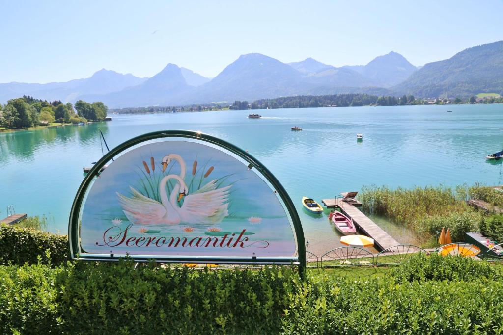a sign for a lake with mountains in the background at Haus Seeromantik in St. Wolfgang