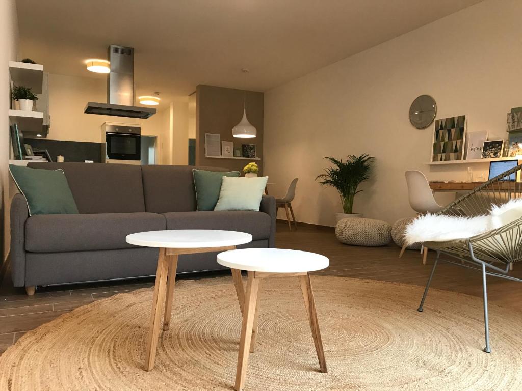 ein Wohnzimmer mit einem Sofa und 2 Tischen in der Unterkunft Nauwieser50 in Saarbrücken