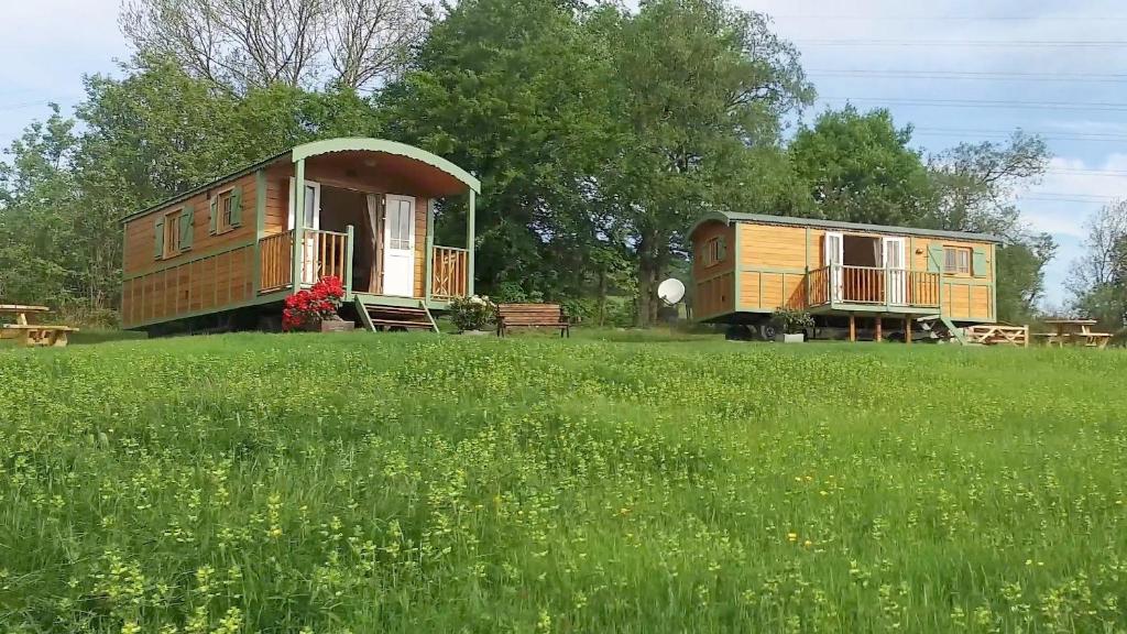 una casa en una colina con un campo de hierba en The Hideaway Huts, en Bardon Mill