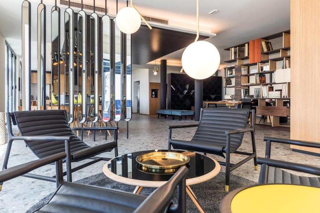 een groep stoelen en tafels in de lobby bij MaisonMe Boutique Hotel in Bardolino