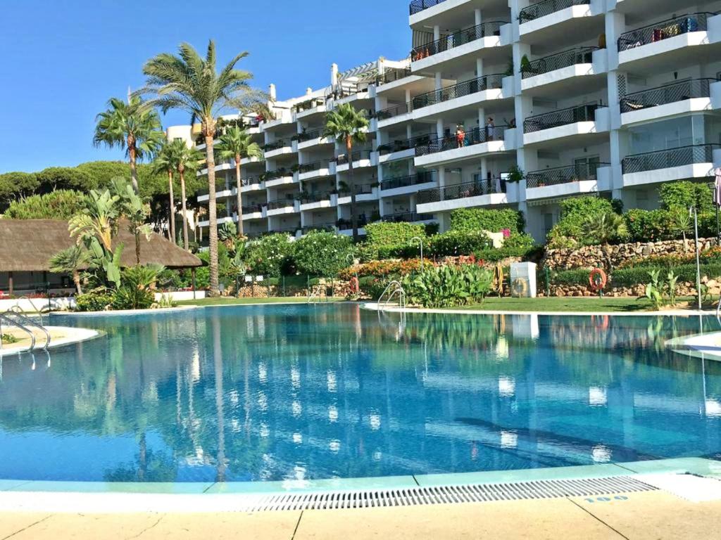 una piscina frente a un gran edificio de apartamentos en SkySea Holidays MI CAPRICHO en Sitio de Calahonda