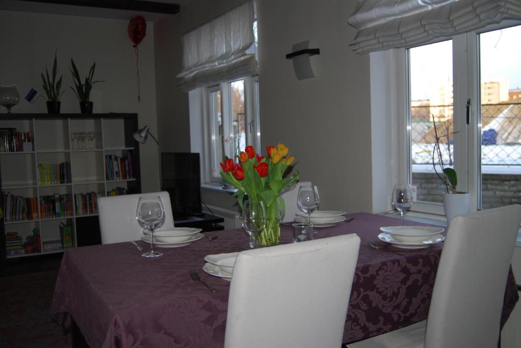 una mesa de comedor con un mantel púrpura y flores en City Centre Duplex Apartment, en Tallin