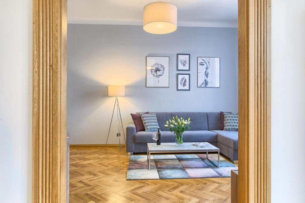 un soggiorno con divano blu e tavolo di Spacious And Bright Apartment Dusni 13 a Praga