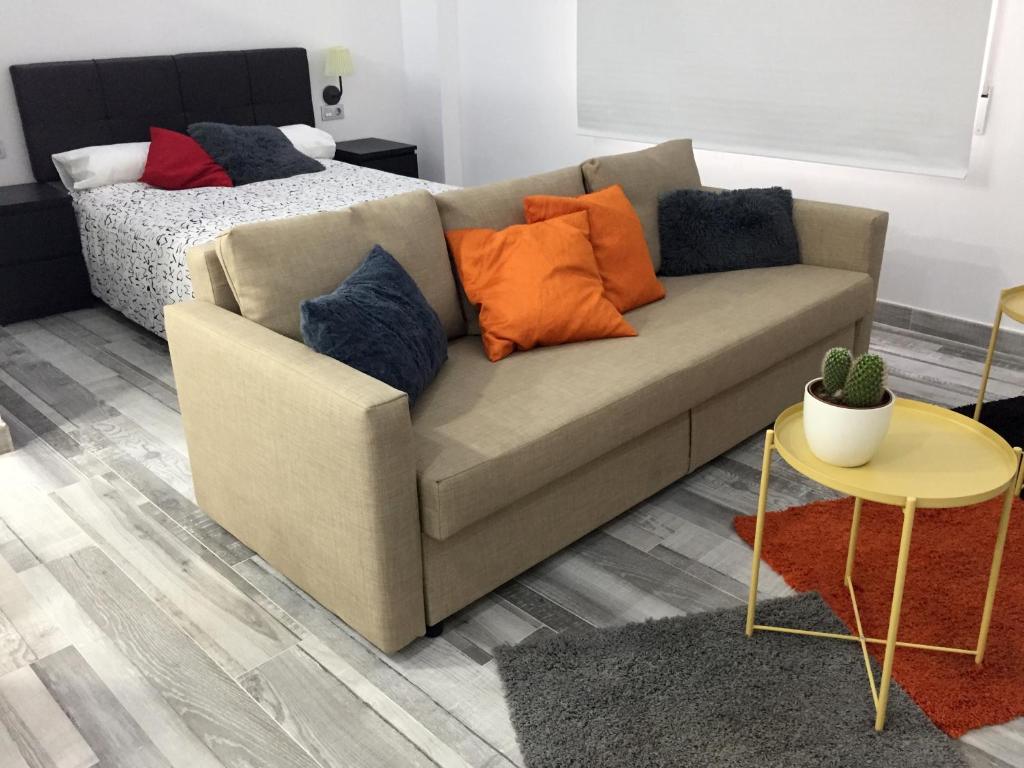 un sofá con almohadas en la sala de estar en Loft Alfa, en Castellón de la Plana