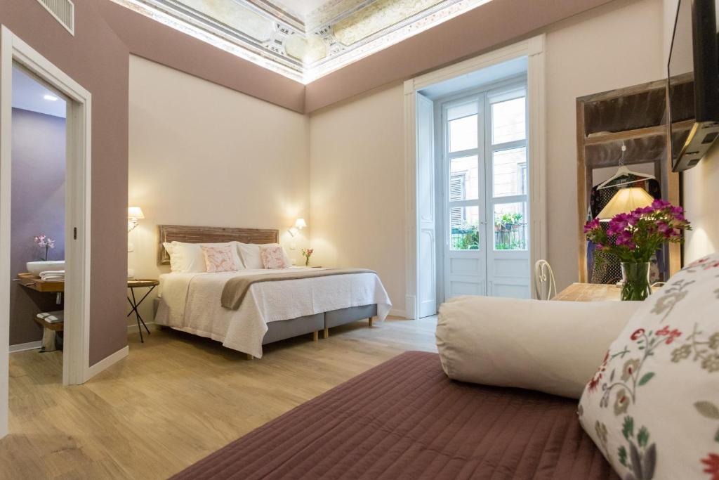a bedroom with a bed and a large window at Bellaroto Suite & SPA in Palermo
