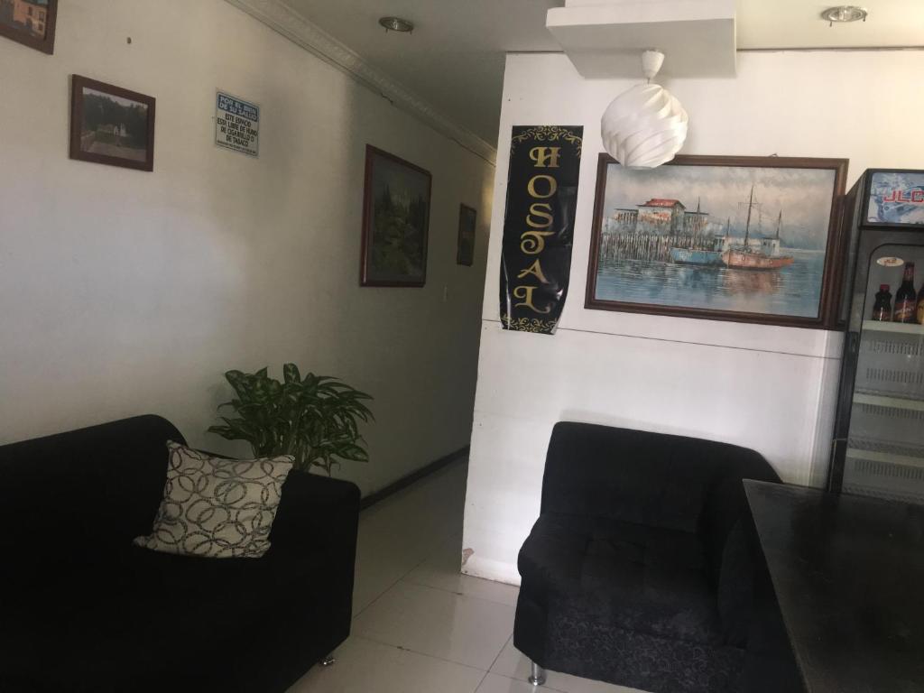 a living room with two black couches and a wall at Hostal Balcony in Popayan