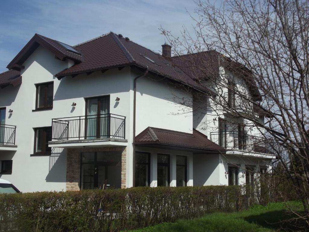 a white house with a brown roof at Pokoje Gościnne "MARIA" in Białogóra