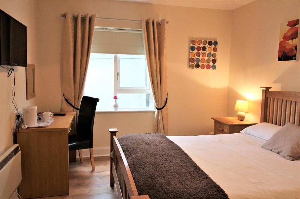 a bedroom with a bed and a desk at The Connaught Inn in Castlebar