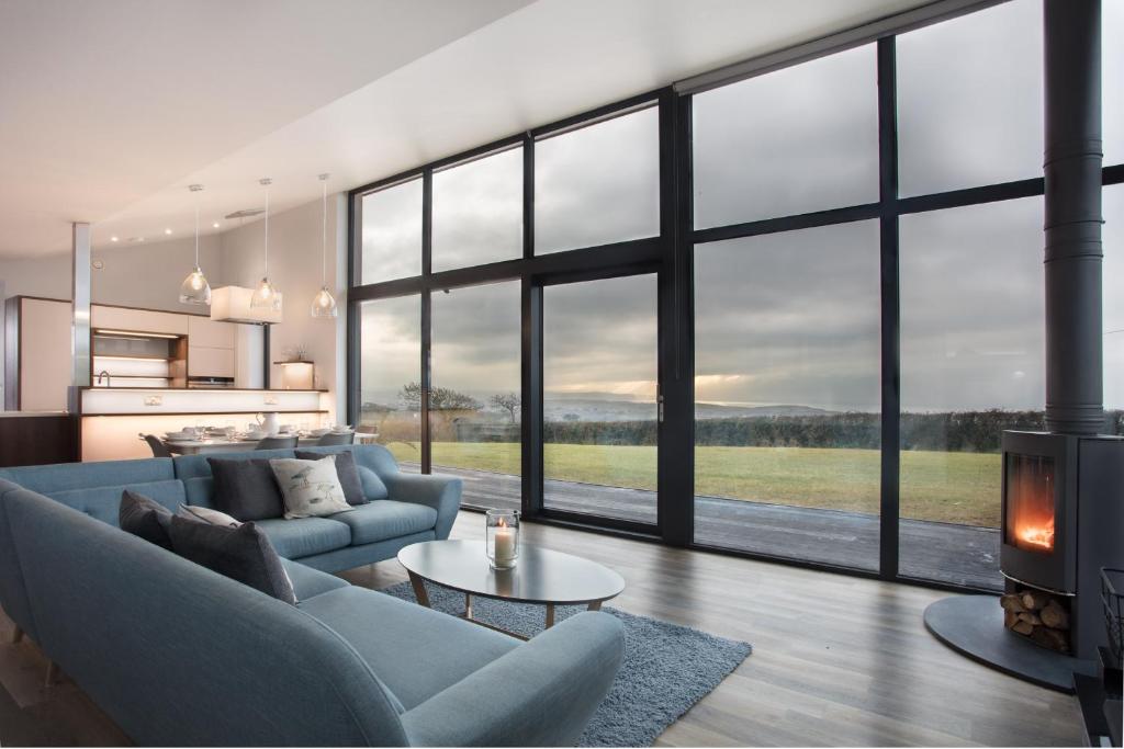 a living room with a couch and a fireplace at Wooda Farm Holidays in Bude