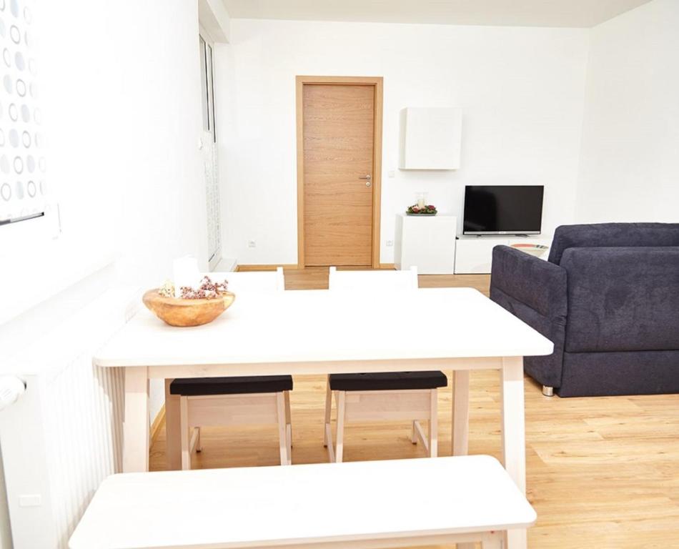 a living room with a white table and a blue couch at Krug-Apartments in Ebelsbach