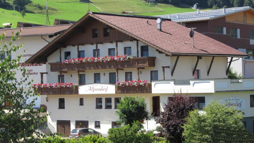 um grande edifício branco com caixas de flores nas suas janelas em Appartement Alpenhof Wildschönau em Niederau