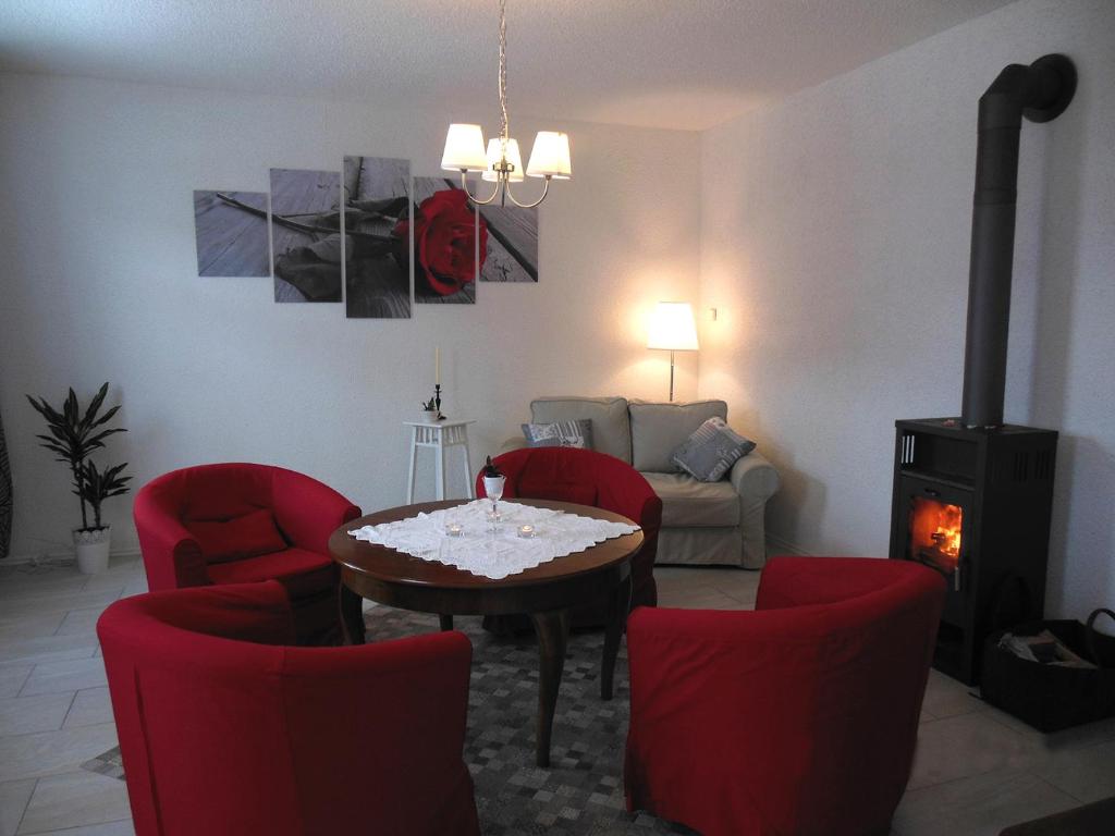 a living room with a table and chairs and a fireplace at FeWo Hottelstedt in Hottelstedt